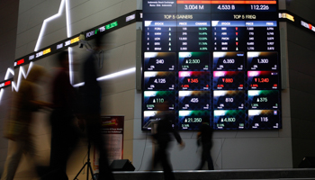 Indonesian traders walk in front of an Indonesia Stock Exchange board in Jakarta (Reuters/Beawiharta)