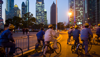 Construction workers ride along a street at central Shanghai (Reuters/Aly Song)