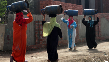 Women carry gas cylinders to be refilled on the outskirts of Cairo (Reuters/Asmaa Waguih)