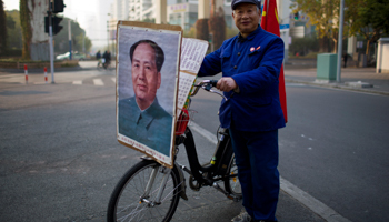 A retired worker poses for a photograph with his bicycle (Reuters/Aly Song)