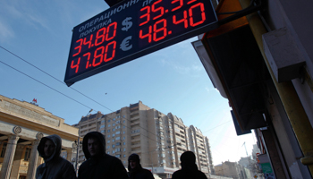 People walk past a currency exchange showing rouble exchange rates in Moscow (Reuters/Maxim Shemetov)