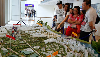 Prospective buyers look at a model of upcoming public housing estates at the Housing Development Board gallery in Singapore (Reuters/Edgar Su)