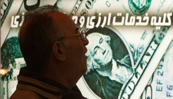 An Iranian man walks past a currency exchange shop in northern Tehran (Reuters/Morteza Nikoubazl)