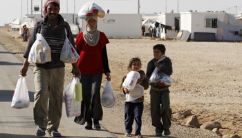 A Syrian refugee family walks after collecting their supplies at the Zaatri refugee campin Jordan (Reuters/Muhammad Hamed)