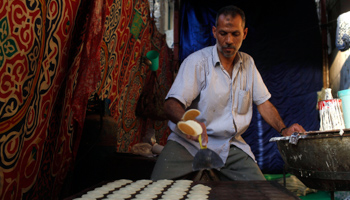 A worker flips sweet pieces which are specially made during the Muslim fasting month of Ramadan in Cairo (Reuters//Asmaa Waguih)