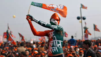 A supporter of India's main opposition Bharatiya Janata Party waves the party's flag during a rally (Reuters/Ahmad Masood)