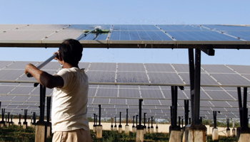 A worker cleans photovoltaic solar panel inside a solar power plant in India (Reuters/Amit Dave)