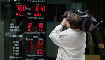 A cameraman films a billboard displaying currency exchange rates in Buenos Aires (Reuters/Enrique Marcarian)