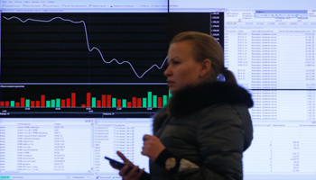 A woman walks past an information screen at the Moscow Exchange (Reuters/Maxim Shemetov)