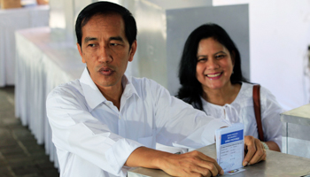 Jakarta governor Joko Widodo and his wife cast their ballot papers (Reuters/Beawiharta)