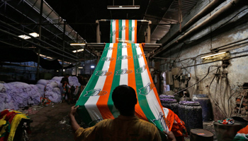 A worker holds a roll of flags of India's ruling Congress party after dying in the colours at a flag manufacturing factory ahead of the 2014 general elections (Reuters/Amit Dave)