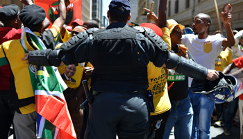 A police officer tries to control ANC supporters as they attempt to confront members of the opposition Democratic Alliance party marching in central Johannesburg (Reuters/Mujahid Safodien)