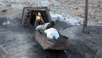 Workers push a cart carrying coal in Mongolia (Reuters/B.Rentsendorj)