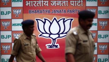 Security personnel walk past a hoarding of India's main opposition party (Reuters/Adnan Abidi)