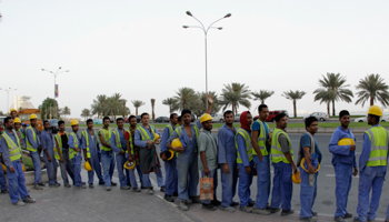 Foreign workers wait for their bus at a construction site in Doha (Reuters/Fadi Al-Assaad)