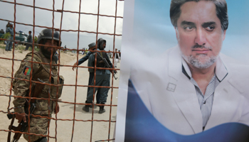 Afghan security forces near a poster of Afghan presidential candidate Abdullah Abdullah (Reuters/Omar Sobhani)