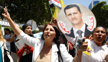 A woman holds a placard of Syria's President Bashar al-Assad in Tunis (Reuters/Zoubeir Souissi)