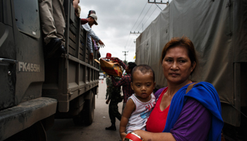 A Cambodian migrant worker next to military trucks (Reuters/Athit Perawongmetha)