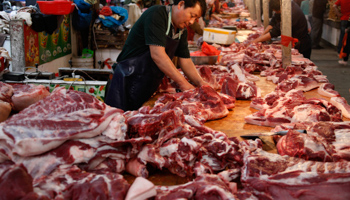 A vendor chops pork at a market (Reuters/Stringer)