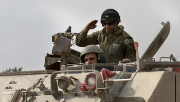An Israeli soldier salutes atop an armoured personnel carrier (Reuters/Baz Ratner)