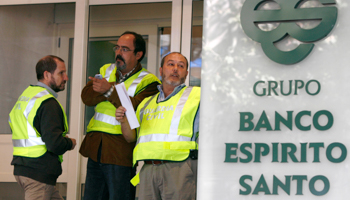 Spanish civil guard officers stand at the entrance of Portugal's Banco Espirito Santo office (Reuters/Sergio Perez)