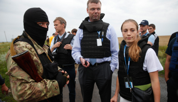 Organisation for Security and Cooperation in Europe (OSCE) monitors speak with a pro-Russian separatist (Reuters/Maxim Zmeyev)