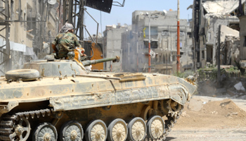 A Syrian soldier sits atop a tank in Mleiha, which lies on the edge of the eastern Ghouta region near Damascus airport. (Reuters/Omar Sanadiki)