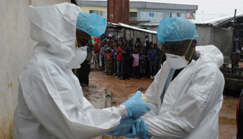 Health workers wear protective clothing before carrying an abandoned dead body presenting with Ebola symptoms at Duwala market in Monrovia (Reuters/2Tango)