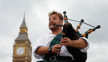 Busker plays the bagpipes near Big Ben and the Houses of Parliament in central London (Reuters/Suzanne Plunkett)