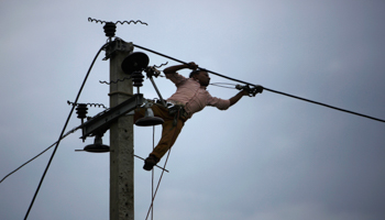 A worker installs new cables on an electric pole in Kathmandu (Reuters/Navesh Chitrakar)