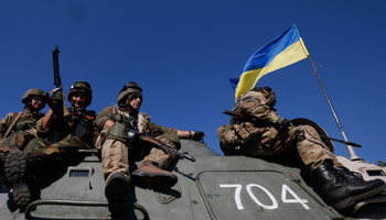 Ukrainian servicemen ride on an armoured vehicle near the eastern Ukrainian town of Pervomaysk (Reuters/David Mdzinarishvili)