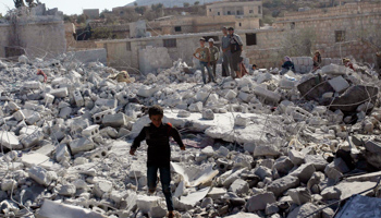 Residents inspect damaged buildings in what activists say was a US strike, in Kfredrian, Idlib province (Reuters/Abdalghne Karoof)