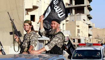 Militant Islamist fighters wave flags as they take part in a military parade (Reuters/Stringer)