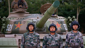 Soldiers of People's Liberation Army stand in front of a tank (Reuters/Petar Kujundzic)