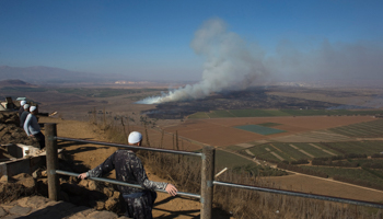 Druze men look at smoke rising on the Israeli-controlled side of the line dividing the Israeli-occupied Golan Heights from Syria (Reuters/Ronen Zvulun)