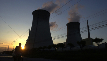 A cyclist rides past a China Huaneng Group power plant in Beijing (Reuters/China Newsphoto)