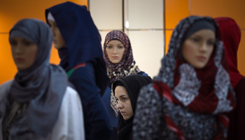 A woman walks past mannequins covered with Islamic clothing in central Tehran (Reuters/Morteza Nikoubazl)