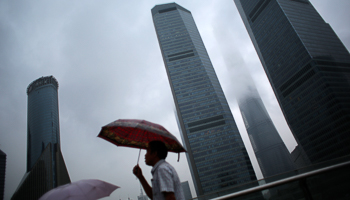 A man walks in the rain along the financial district of Pudong, Shanghai (Reuters/Carlos Barria)