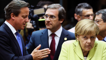 Merkel gestures as Cameron and Coelho talk during the European Union leaders summit in Brussels (Reuters/Francois Lenoir)