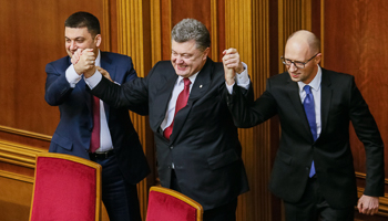 Poroshenko holds up the hands of Arseny Yatseniuk and Volodymyr Groysman during a parliament session in Kiev (Reuters/Gleb Garanich)