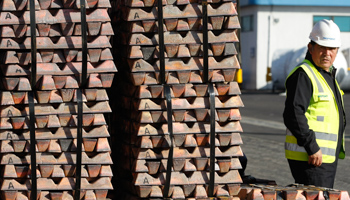 A security guard stands next to a shipment of copper ready to be delivered in Valparaiso city (Reuters/Eliseo Fernandez)