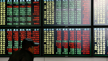 An investor looks at information displayed on an electronic screen at a brokerage house in Shanghai (Reuters/Aly Song)