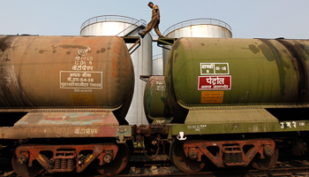 A worker walks atop a tanker wagon at an oil terminal on the outskirts of Kolkata (Reuters/Rupak De Chowdhuri)