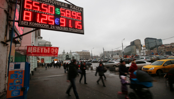 People walk past boards showing currency exchange rates in Moscow (Reuters/Maxim Zmeyev)
