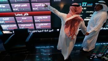 Investors talk as they monitor screens displaying stock information at the Saudi Stock Exchange in Riyadh (Reuters/Faisal Al Nasser)