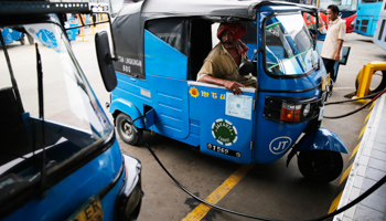 A driver sits inside his Bajaj auto rickshaw as he fills gas at a state-owned Pertamina gas station in Jakarta (Reuters/Beawiharta)