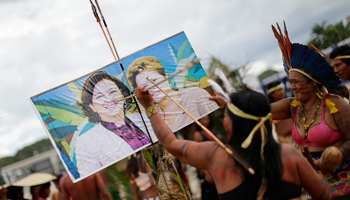 A woman pokes an image of Abreu and Rousseff during a protest in Brasilia (Reuters/Ueslei Marcelino)