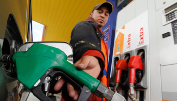 A worker pumps petrol into a car at a gas station in Quito (Reuters/Guillermo Granja)