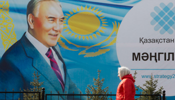 A woman walks past a poster of President Nursultan Nazarbayev (Reuters/Shamil Zhumatov)