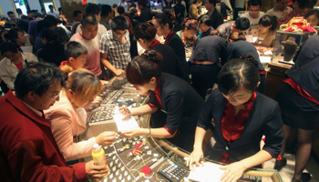 Customers look at gold accessories at a gold store in Jinan, Shandong province (Reuters/Stringer)